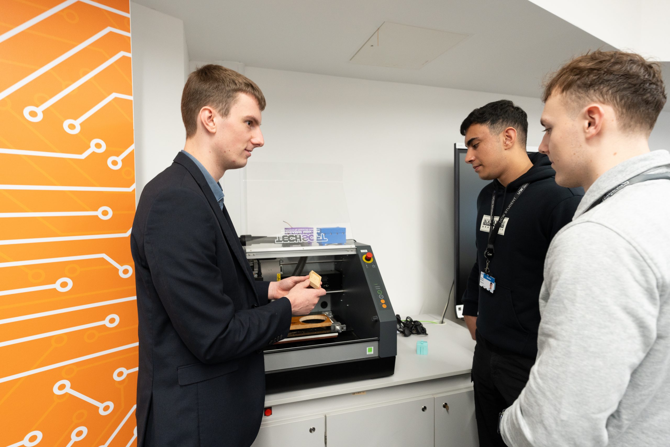 Jack showing a piece of equipment to students.