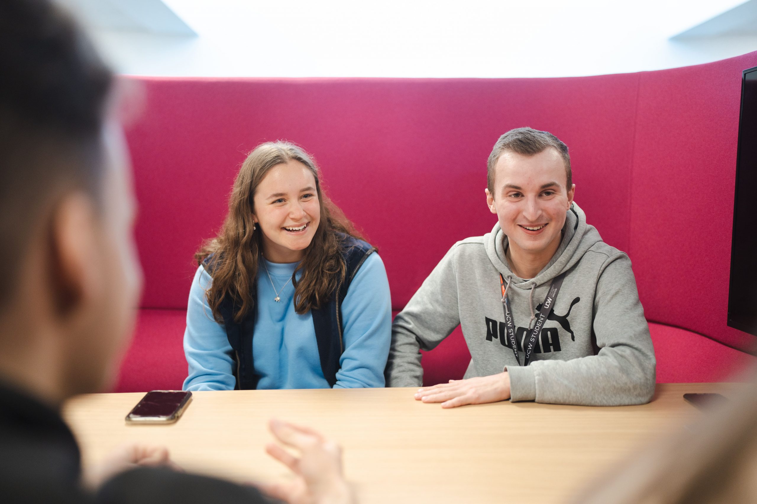 two students sat at a table smiling