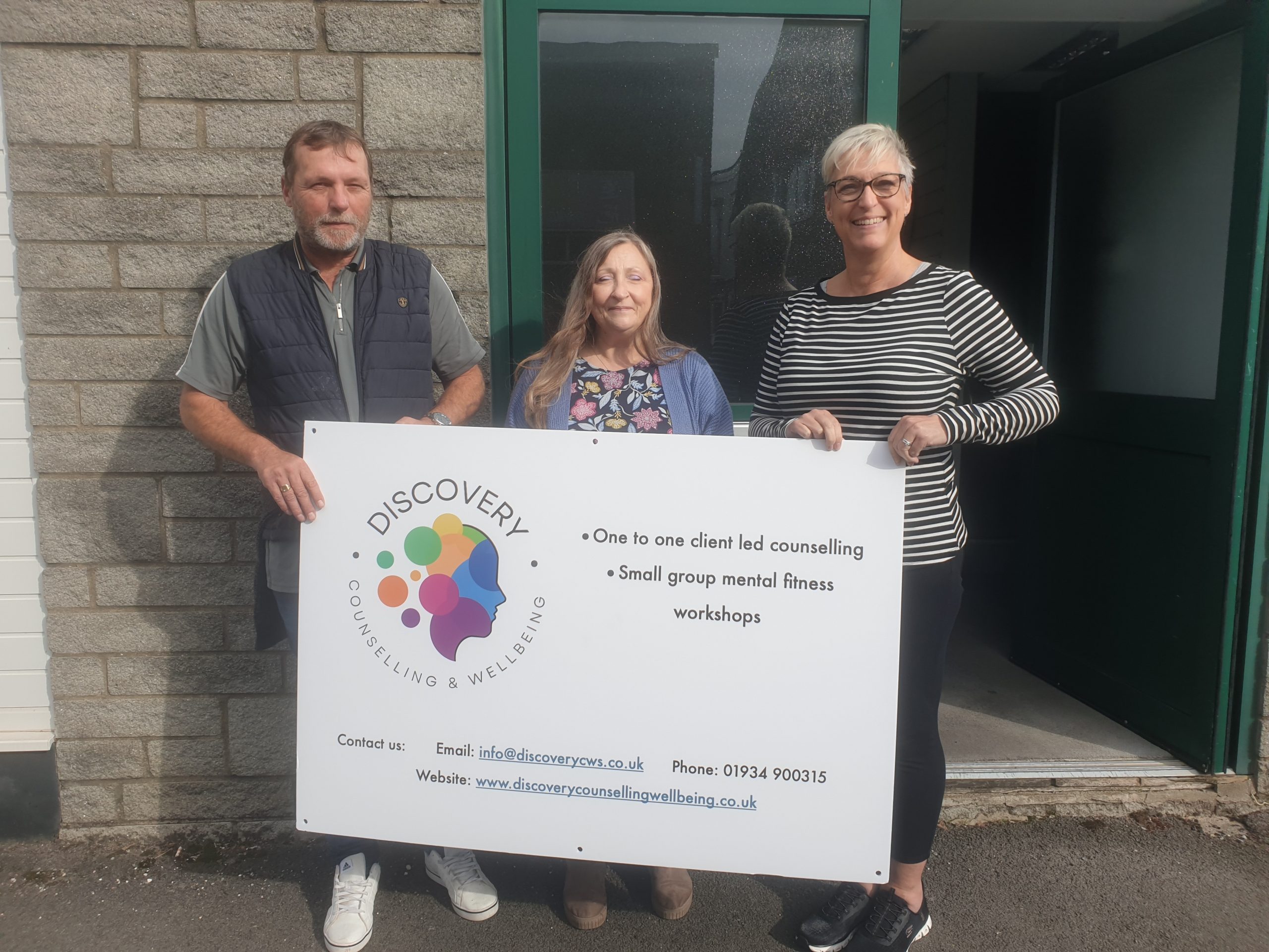 Shaun, Nicola and Heidi with a sign for Discovery Counselling and Wellbeing