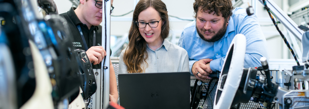 a group of 3 engineering students looking at a laptop